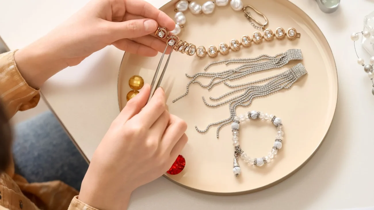 Hands using tweezers to assemble handmade jewelry