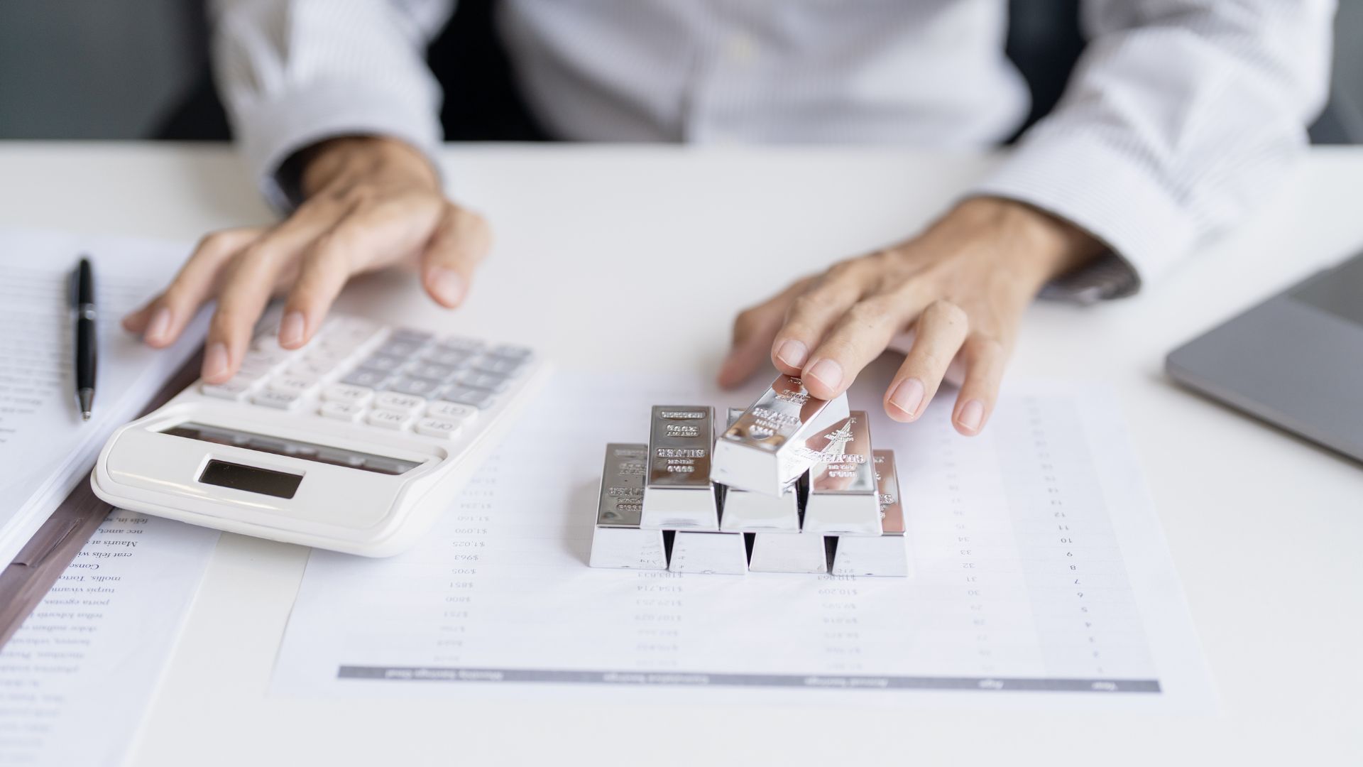 Goldsmith calculating silver bar price