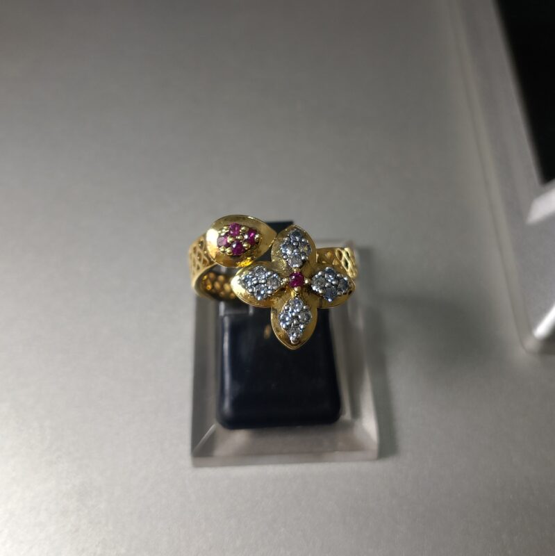 This is a gold toned flower motif ring featuring ruby and diamond Copy