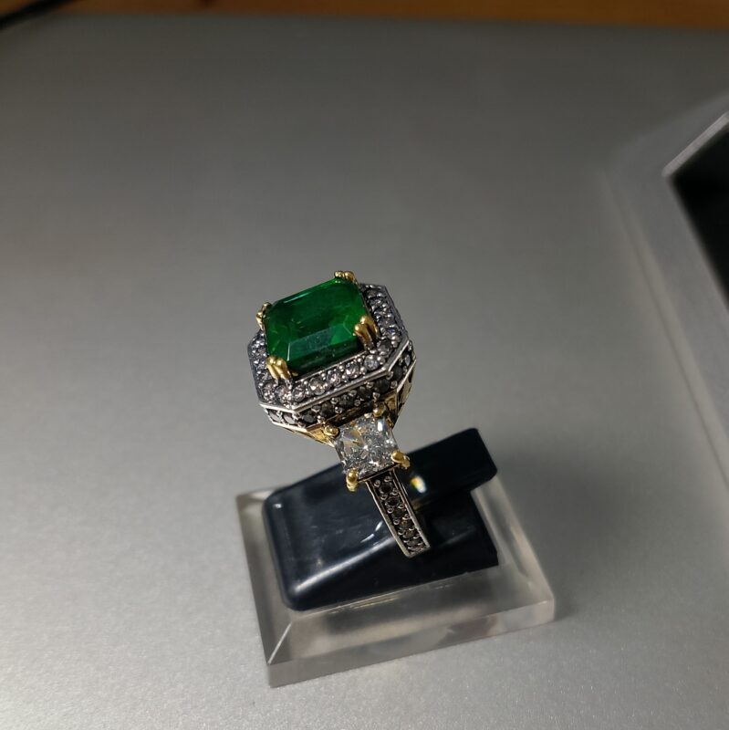 emerald cut emerald and diamond three stone ring with a two tone setting 3